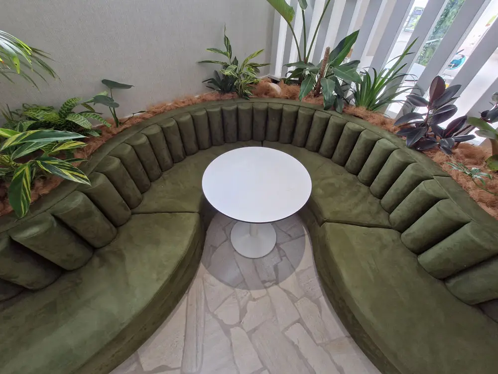 Bolsters made out of green fabric plus custom curved squab seating with round table