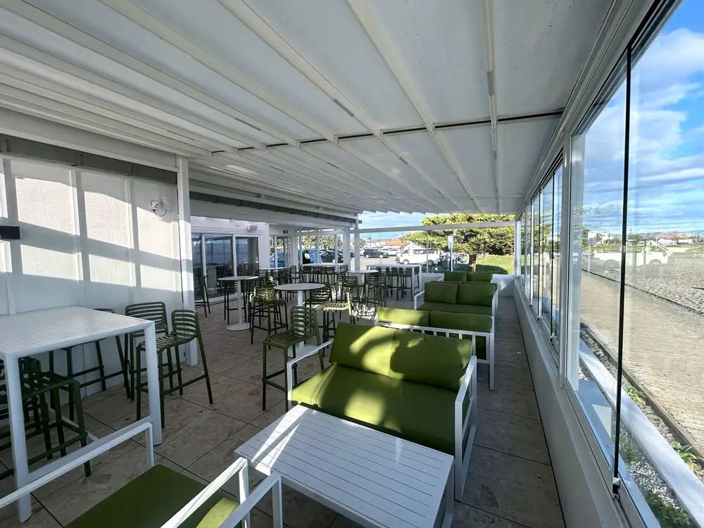 Cocktail bar outdoor area with retractable roof with beach and blue sky in the background