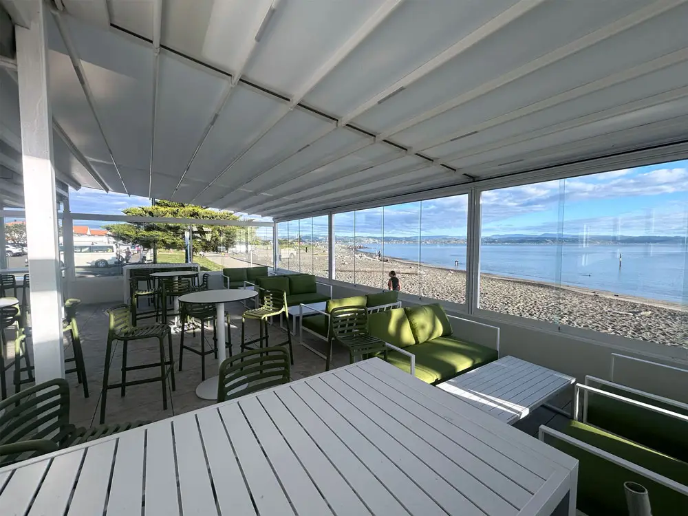 Cocktail bar outdoor area with retractable roof with ocean and blue sky in the background