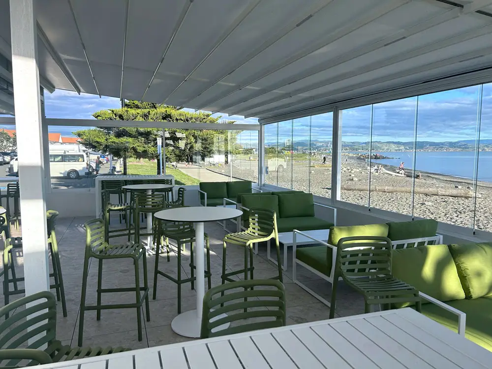 Cocktail bar outdoor area with retractable roof with tree and blue sky in the background