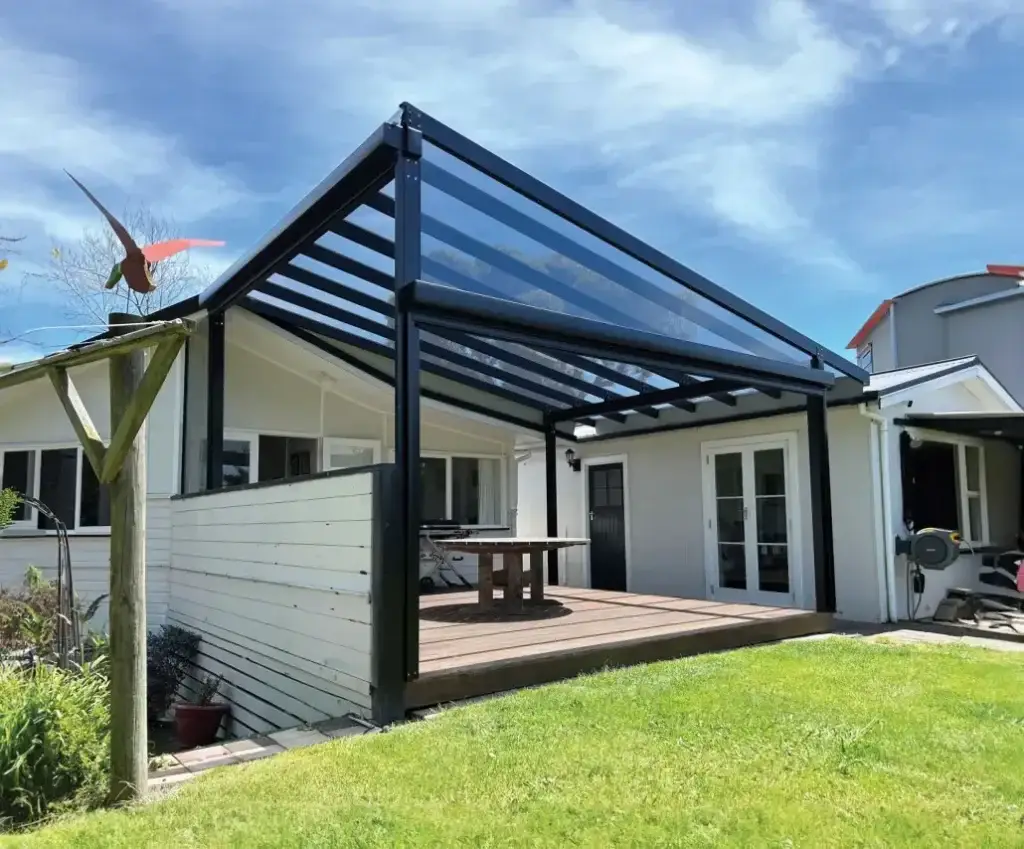 A clear glass roof pergola with custom infill panel, designed and installed by Douglas Hawke's Bay to suit this bespoke patio area in NZ